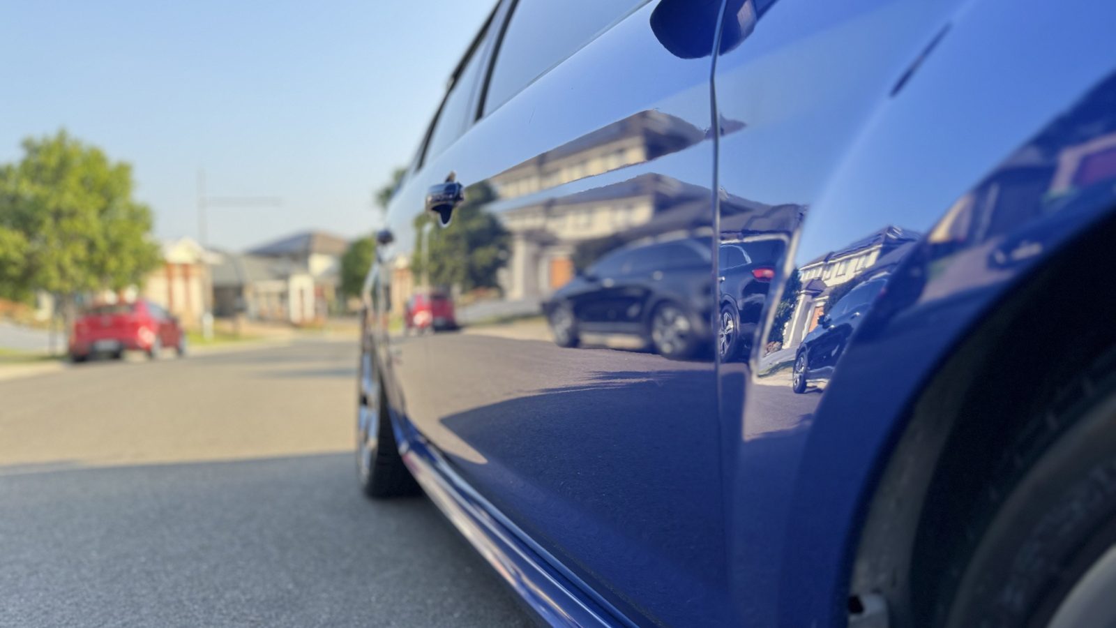 Low angle along the glossy blue side of a Ford Focus