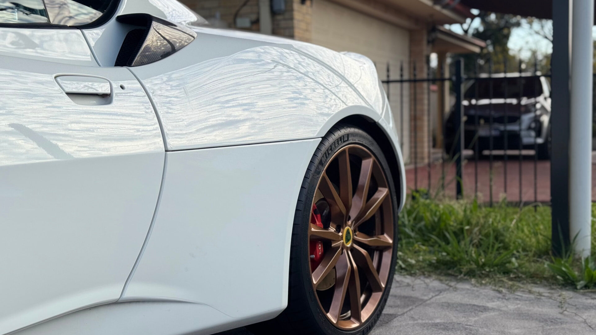 Rear quarter of a white Lotus Evora showing clear reflections