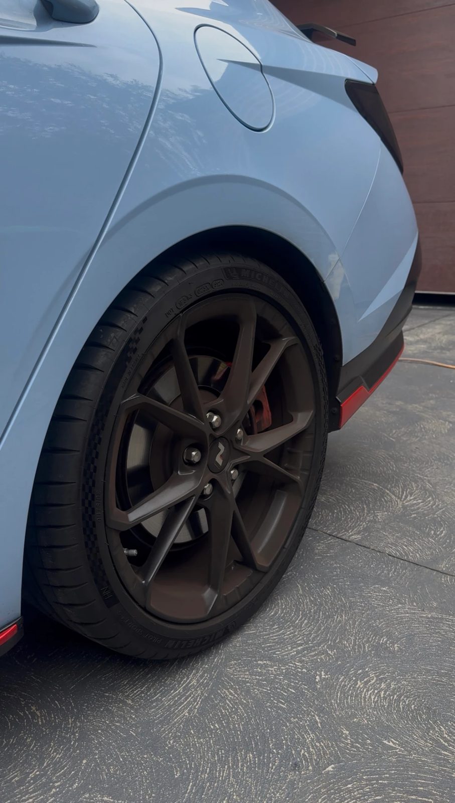 Rear wheel of a Hyundai i30 N coated in brown brake dust before cleaning