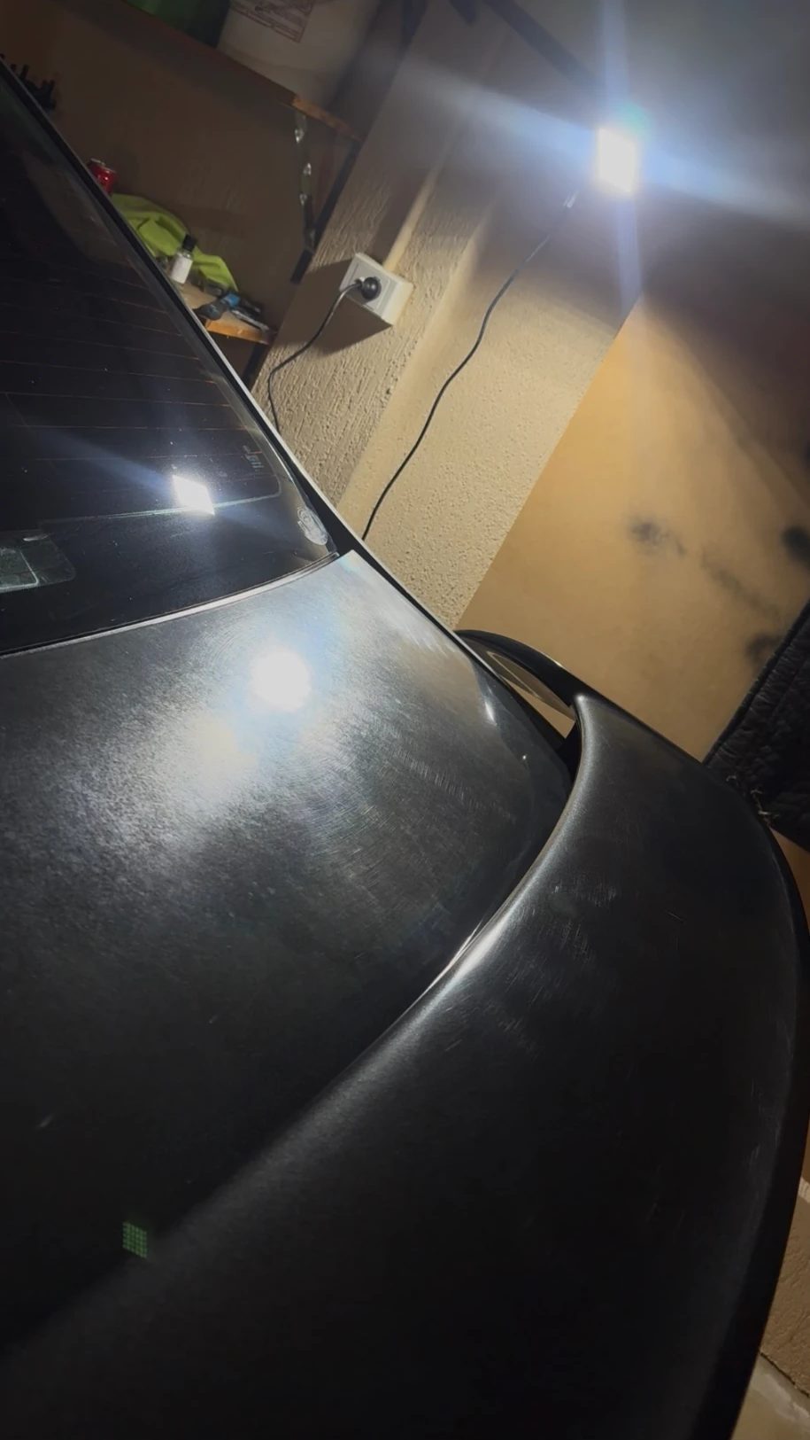 Ford Falcon bootlid and spoiler covered in swirl marks under an inspection light