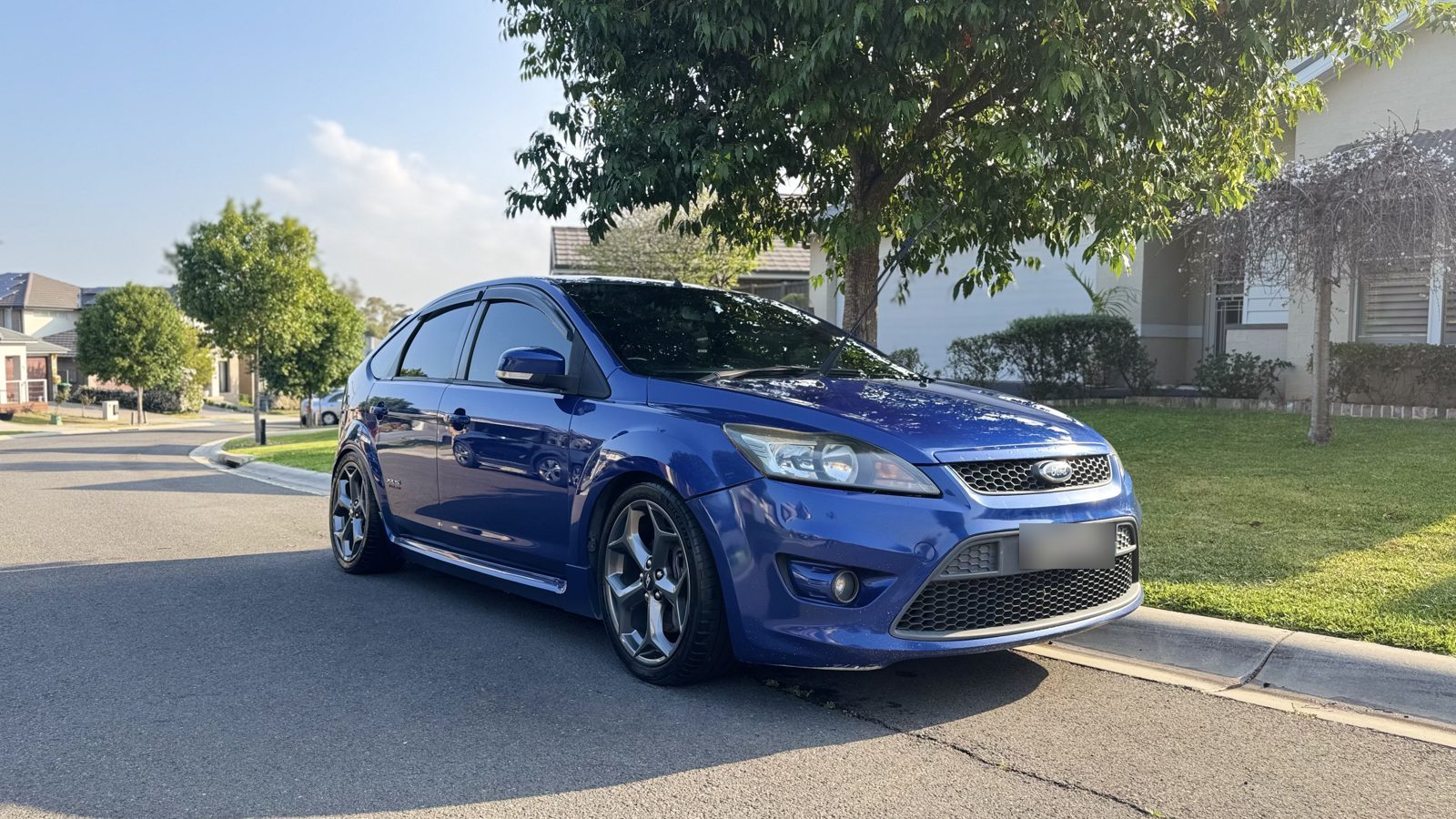 Blue Ford Focus XR5 parked on a suburban street after paint restoration