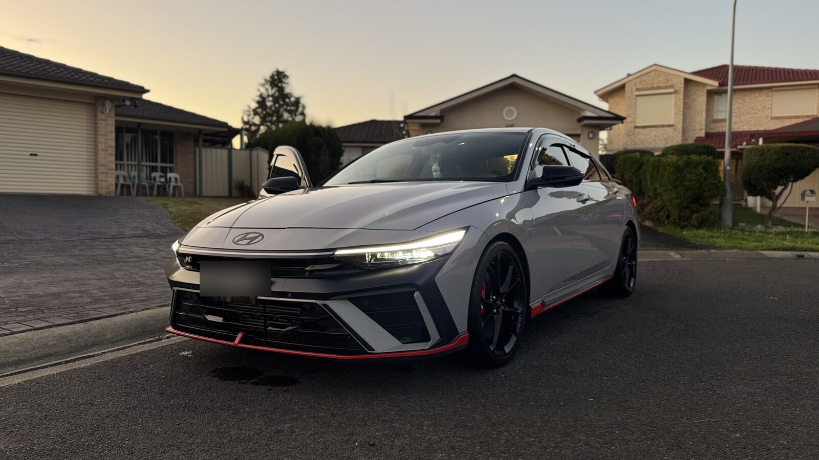 Grey Hyundai i30 Sedan N front view in a suburban street after a detail