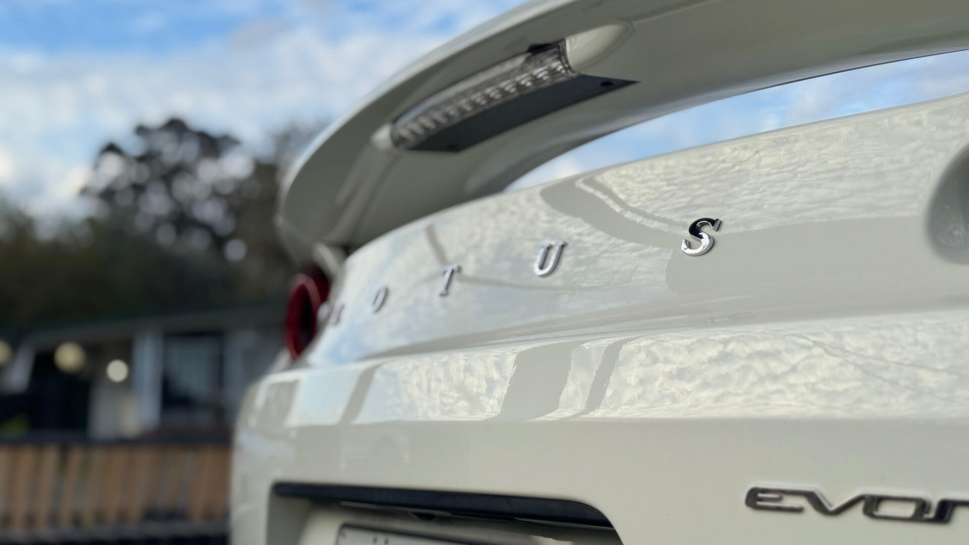 Lotus lettering on a corrected white decklid reflecting the sky